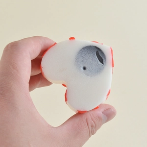 Cute heart-shaped squishy toy with red polka dots and cartoon face for stress relief
