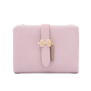 Detail of pink PU leather wallet featuring unique puzzle-shaped metal buckle and zip closure