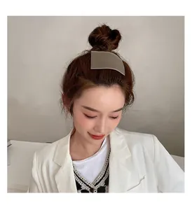 Close-up of a minimalist champagne gold metal hair comb for styling bun hairstyles