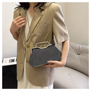Dettaglio elegante borsa a conchiglia nera con strass, cornice argento e catena