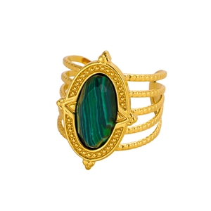 Macro detail of gold vintage ring with green oval malachite and layered metal band