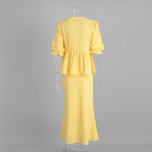 Rear view of yellow V-neck ruffle top and maxi skirt set on a mannequin display