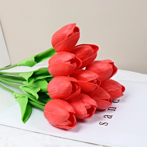 Detail of life-like red PU tulips with realistic petal texture and flexible green stems