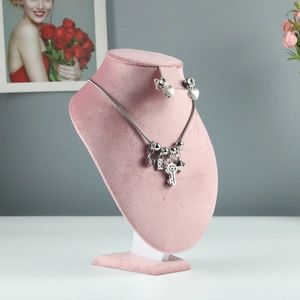 Silver necklace with key heart charms and matching studs on pink velvet display stand