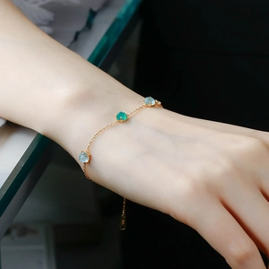 Detail of S925 silver 14k gold bracelet with green chalcedony and white shell on wrist