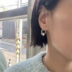 925 silver hoop earrings with heart charms and a twisted bow ear cuff worn on model
