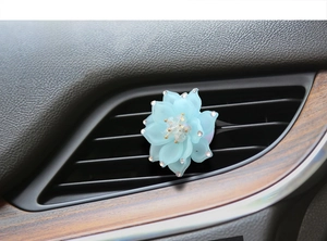 Close-up of a blue lotus car vent clip with sparkling rhinestones and crystal detail