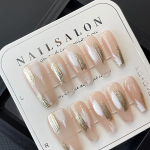 Handmade press-on nails with white graffiti and gold glitter in long coffin shape