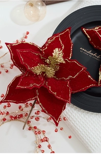 Detail of red velvet poinsettia Christmas flower with gold glitter edges for decor