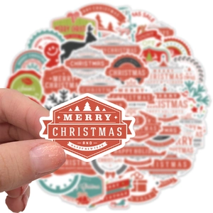 Macro shot of a red and white Merry Christmas decorative sticker held by hand