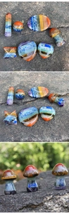Macro shot of 7 natural chakra stones in various shapes including heart and star prisms