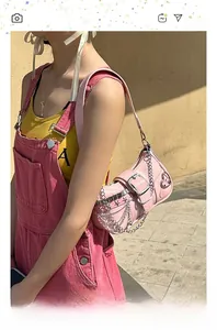 Detailed view of pink Y2K bag with silver stars, heart charms and metal chain link straps