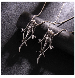 Vue macro de pendentifs pieuvre en métal argenté avec textures sur fond noir élégant