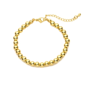 Elegant adjustable golden beaded chain bracelet with teardrop charm on white background