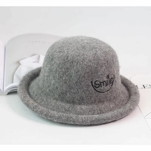 Detailed macro view of gray wool felt hat showing smile embroidery and rolled edge brim