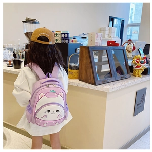 Detailed back view of a purple 3D cartoon cat backpack worn by a toddler girl