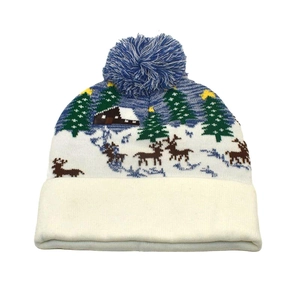 Detailed pattern of reindeer and snow cabins on a blue winter knit Christmas hat