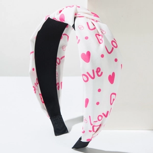 White fabric knotted headband featuring pink LOVE letters and heart print for Valentine Day