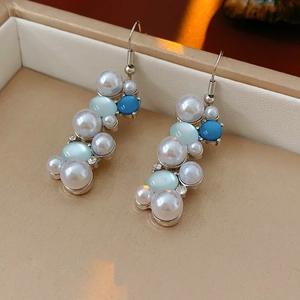 Dettaglio di orecchini vintage con perle e pietre blu in una scatola regalo per gioielli