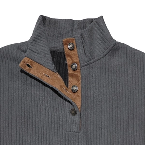Close-up of grey rib-knit collar with brown suede trim and metallic button detail