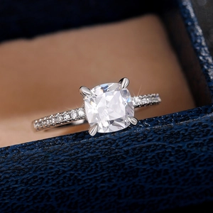 Macro shot of cushion-cut cubic zirconia engagement ring with pavé setting in a gift box