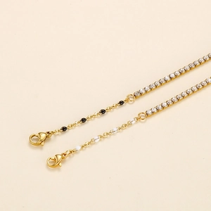 Detail of gold chain bracelet with white crystal link and enamel beads decoration