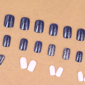 Starry midnight blue press-on nails with silver glitter and pink accents in a round square shape
