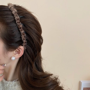 Nahaufnahme des Leoparden-Samtstirnbands mit elegantem weißem Perlen-Schmuck