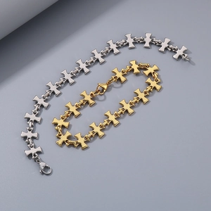 Détail de bracelets croix en acier inoxydable argenté et doré avec fermoirs mousquetons