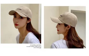 Detail showing beige minimalist baseball cap with fish embroidery and side metal eyelets