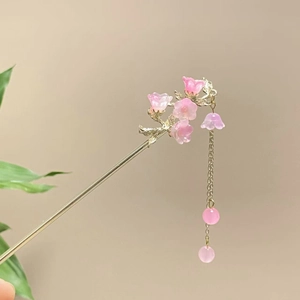 Detail von rosa Blumentüpfeln und goldenem Metallfinish auf chinesischem Haarschmuck
