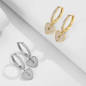 Detailed close-up of heart lock hoop earrings with cubic zirconia in gold and silver