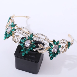 Detailed close-up of a gold floral bridal crown with green and clear zircon crystals