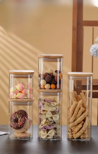Various sizes of square glass storage jars with wooden lids for kitchen organization