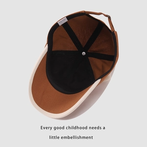 Detail of baby bear baseball cap showing inner lining, size label, and metal buckle