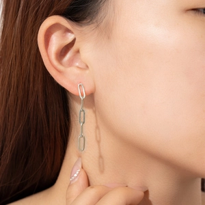 Gros plan de boucles d'oreilles pendantes en argent S925 montrant la longueur portée