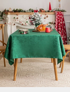 Close-up of green Christmas tablecloth featuring intricate snowflake jacquard patterns