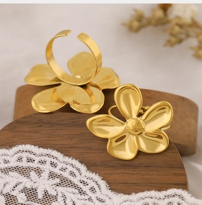 Detailed close-up of 3D gold floral ring on elegant white lace and rustic wood base