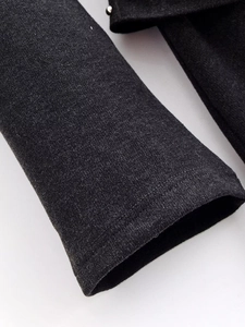 Detailed macro view of charcoal grey knitted fabric texture and fine flat seam stitching