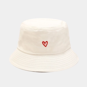 Detailed view of red heart embroidery on a beige cotton canvas bucket hat