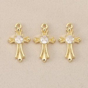 Detail of three vintage 18K gold plated Baroque cross pendants with clear gemstones