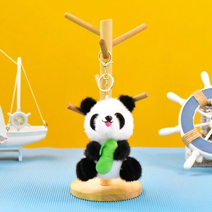 Lindo llavero de peluche de panda con bambú verde en un soporte de madera decorativo