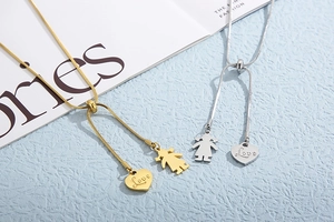 Detailed view of gold and silver heart necklaces with love engraving and girl pendants