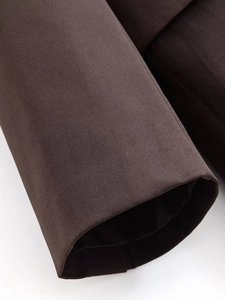 Macro shot of dark brown double-breasted suit fabric texture and cuff stitching detail