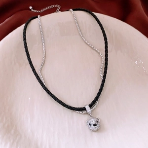 Double-layered necklace with sparkling bear pendant and leather cord on red cloth