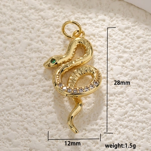 Gold plated snake pendant with zircon inlays and green gem eyes measuring 28mm high
