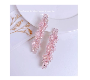 Detail of pink crystal beaded hair clips set with silver metal pins on a white plate