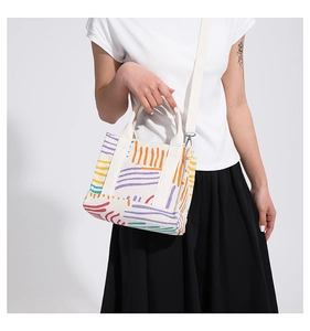 Dettaglio della borsa tote in velluto a coste crema con stampa colorata su modella