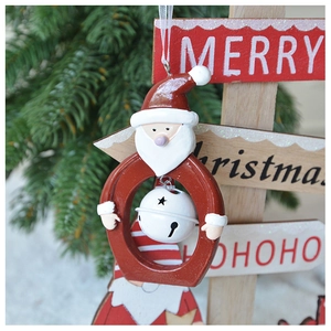 Detail of resin Santa Claus ornament with a white metal bell and silk hanging string