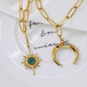 Detail of 14K gold paperclip chain with sun gem pendant and rainbow moon charm